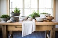 raw wood table with stoneware bowls, linen runners, and fresh herbs in pots Royalty Free Stock Photo