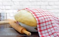 Raw yeast dough covered with a towel in a bowl Royalty Free Stock Photo