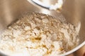 Raw yeast dough mixing in large metal bowl in mixer. Flour, water and yeast mixing Royalty Free Stock Photo