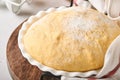 Raw yeast dough with pumpkin in white bowl covered with towel on the floured kitchen table, recipe idea. Concept home baking bread Royalty Free Stock Photo