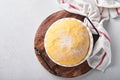 Raw yeast dough with pumpkin in white bowl covered with towel on the floured kitchen table, recipe idea. Concept home baking bread Royalty Free Stock Photo