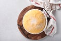 Raw yeast dough with pumpkin in white bowl covered with towel on the floured kitchen table, recipe idea. Concept home baking bread Royalty Free Stock Photo