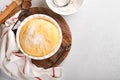 Raw yeast dough with pumpkin in white bowl covered with towel on the floured kitchen table, recipe idea. Concept home baking bread Royalty Free Stock Photo