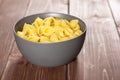 Raw yellow pasta conchiglie on brown wood Royalty Free Stock Photo