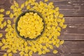 Raw yellow pasta conchiglie on brown wood Royalty Free Stock Photo