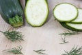 Raw zucchini in pieces with fennel on wooden background Royalty Free Stock Photo