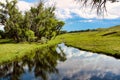 Summer Stormy Sky Reflected in Rawhide Creek on Harris Ranch Road in Eastern Wyoming. Royalty Free Stock Photo