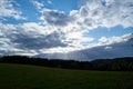 A ray of light breaks through the dramatic sky at sunset and hit an oak tree solitary Royalty Free Stock Photo