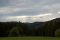 A ray of light breaks through the dramatic sky at sunset and hit an oak tree solitary Royalty Free Stock Photo