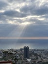 Ray of light through the clowds on the town and calm blue sea