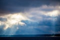 The rays of God in the river landscape. The sun`s rays shine through the clouds over the water surface and the shore Royalty Free Stock Photo