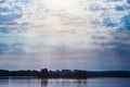 The rays of God in the river landscape. The sun`s rays shine through the clouds over the water surface and the shore. Copy space Royalty Free Stock Photo