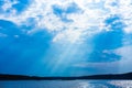 The rays of God in the river landscape. The sun`s rays shine through the clouds over the water surface and the shore. Copy space Royalty Free Stock Photo