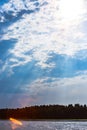 The rays of God in the river landscape. The sun`s rays shine through the clouds over the water surface and the shore. Copy space Royalty Free Stock Photo