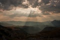 Rays of Light from behind the clouds ower the mountain ridge Royalty Free Stock Photo