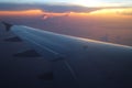 Rays of light in twilight sunset purple orange sky view from window airplane wings Royalty Free Stock Photo