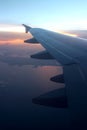 Rays of light in twilight sunset purple orange sky view from window airplane wings Royalty Free Stock Photo