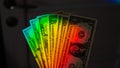 Rays of a rainbow on a man's hand with a bundle of dollars. Royalty Free Stock Photo