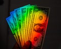 Rays of a rainbow on a man's hand with a bundle of dollars. Royalty Free Stock Photo