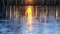 Rays of the setting sun are reflected in the river water which began to be covered with the first ice Royalty Free Stock Photo