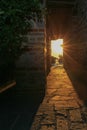 The rays of the setting sun shine through the narrow long arch of the building of the monastery on Mount Athos Royalty Free Stock Photo