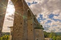 Rays of sun through arch of aqueduct at entrance to city of Orte, Italy