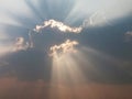 rays of the sun breaking through from behind the cloud along its entire contour, against the dark sky. Royalty Free Stock Photo