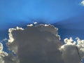 Rays of the sun breaking through the dark clouds on the blue sky background Royalty Free Stock Photo