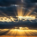 Rays of sunlight break through dark, thick clouds, creating a dramatic sky. The golden Royalty Free Stock Photo