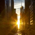 Rays of sunlight shining between the skyline buildings along 42nd Street in Midtown Manhattan, New York City Royalty Free Stock Photo