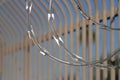 Razor wire closeup with bar fence Secrity Location Royalty Free Stock Photo