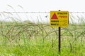 Razor wire guard fence and warning sign on mines field Royalty Free Stock Photo