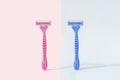 Razors with gender colors against pink and blue background Royalty Free Stock Photo