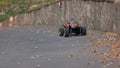 RC monster truck rides on the road and blows up leaves.