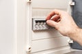 An RCD circuit breaker board with many switches. Man`s hand is about switch OFF Royalty Free Stock Photo