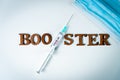 3rd covid vaccine booster shot concept with face mask. Syringe is seen on table as a concept for the 3rd covid-19 vaccine dose, Royalty Free Stock Photo