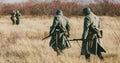 Re-enactors Dressed As German Infantry Soldiers In World War II Marching Walking Along Meadow In Cold Autumn Day