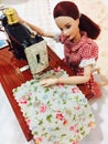 A beautiful barbie doll is sewing her clothes.