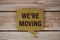 We\'re Moving text with speech bubble top view on wooden background Royalty Free Stock Photo