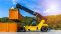 Reach stacker yellow forklift truck handling shipping container in business import export logistic shipping yard with cargo Royalty Free Stock Photo