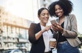 Reaching out to new networks. Shot of two businesswomen looking at something on a cellphone in the city. Royalty Free Stock Photo