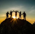 Reaching for the Summit: Silhouettes of People on a Mountain . Royalty Free Stock Photo