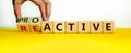 Reactive or proactive symbol. Businessman hand turns cubes and changes the word reactive to proactive. Business and reactive or