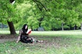 Read a book sitting under a blossom tree Royalty Free Stock Photo