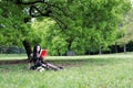 Read a book sitting under a blossom tree Royalty Free Stock Photo