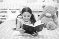 Read fairytale in bed. Girl child lay bed with teddy bear read book. Kid prepare to go to bed. Time for evening Royalty Free Stock Photo