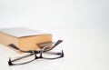 Read glasses selective focus on blur Bookmark in old book on white background Royalty Free Stock Photo