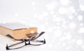 Read glasses selective focus on blur Bookmark in old book on white bokeh background Royalty Free Stock Photo