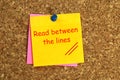 read between the lines postit on corkboard Royalty Free Stock Photo