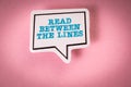 Read Between The Lines. Speech bubble with text on pink background Royalty Free Stock Photo